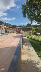 a picnic table on a retaining wall next to a pool at Sitio Walll in Sao Jose da Lapa