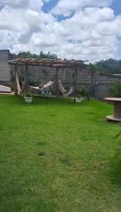 a backyard with a hammock in the grass at Sitio Walll in Sao Jose da Lapa