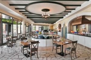 a restaurant with tables and chairs and a bar at JA Palm Tree Court, Dubai in Dubai