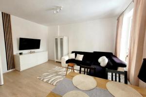 a living room with a black couch and a tv at Przystanek Sudety in Wałbrzych +5 photos