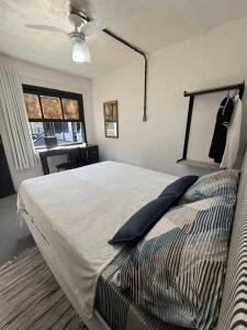 a bedroom with a bed with a ceiling fan and a window at Hostel El viajero in Tramandaí