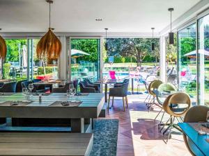 a restaurant with tables and chairs and a patio at Novotel Lens Noyelles in Noyelles-Godault