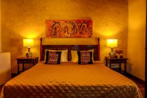 a bedroom with a bed with two lamps on both sides at Villa de Antaño in Antigua Guatemala
