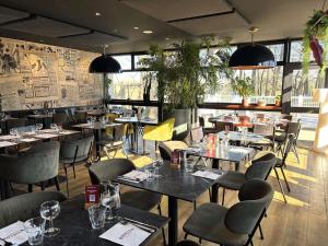 a restaurant with tables and chairs in a room at ibis Styles Lorient Caudan in Caudan