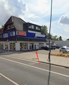 a building with an orange arrow in front of a street at Praktische Monteurwohnung 2 Marl in Marl