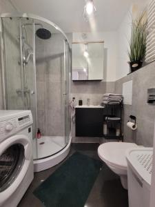 a bathroom with a shower and a washing machine at Przystanek Sudety in Wałbrzych