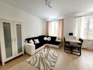 a living room with a black couch and a table at Przystanek Sudety in Wałbrzych