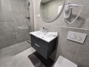 a bathroom with a sink and a shower and a mirror at Apartments Goro in Podstrana