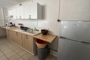 a kitchen with a sink and a refrigerator at La Baraka in Dzaoudzi +8 photos
