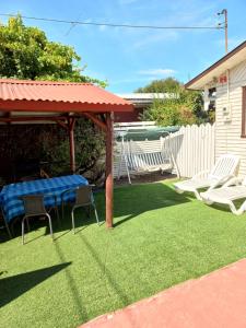 a backyard with a picnic table and chairs on the grass at Cabañas casa blanca in Laraquete