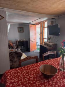a living room with a table with a red table cloth at Cabañas casa blanca in Laraquete