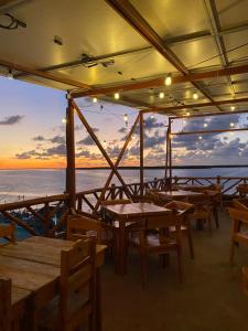 a restaurant on a boat with tables and chairs at Hotel y Restaurante Macumba in Río Lagartos