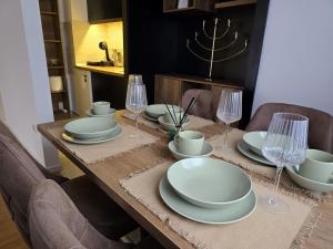 a dining room table with plates and wine glasses at ENA Lux in Novi Pazar