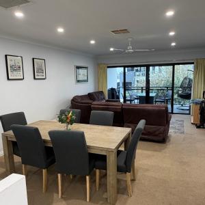 a living room with a table and a couch at Moana Seaside Retreat - 2 Bedroom, spa , living area & pet friendly in Moana