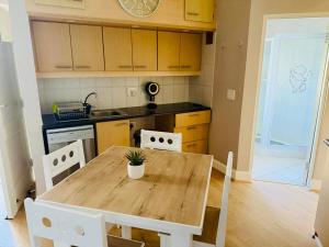 a kitchen with a wooden table and white chairs at Beachside Bliss Gordons Bay in Gordonʼs Bay