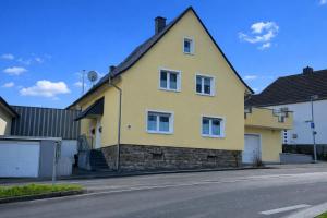 ein gelbes Haus am Straßenrand in der Unterkunft Wolke13 - gemütliche 2 Zimmer Wohnung mit voll ausgestatteter Küche in der City von Menden in Menden