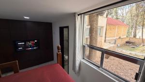 a bedroom with a window with a view of a yard at Villa 1 TRES SENDEROS in Omitlán de Juárez