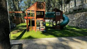 a small playground with a play structure in the grass at Villa 1 TRES SENDEROS in Omitlán de Juárez
