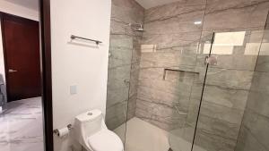 a bathroom with a toilet and a glass shower at Villa 1 TRES SENDEROS in Omitlán de Juárez +29 photos