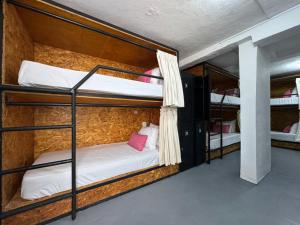 a room with three bunk beds in a hostel at The Boat House Cancun in Cancún