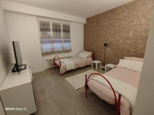 a room with two beds and a tv in it at La casa dell'orsetta in Loano