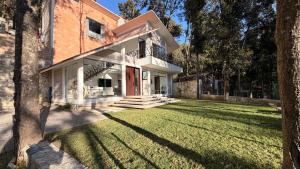 an old brick house with a grass yard at Villa 1 TRES SENDEROS in Omitlán de Juárez