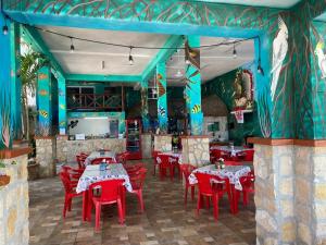 a restaurant with red chairs and tables and blue walls at Hotel y Restaurante Macumba in Río Lagartos