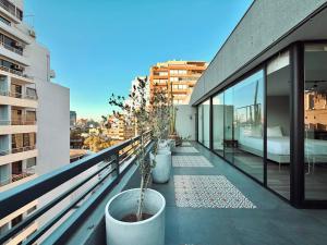 a balcony with potted plants on a building at Hotel Tempo Rent in Santiago