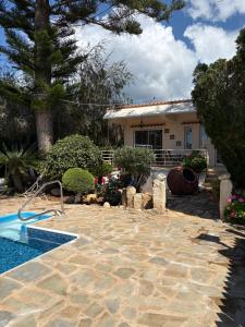 a backyard with a swimming pool and a house at Villa Filip Coral Bay in Peyia