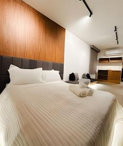 a bedroom with a large white bed with a wooden headboard at Lapa Enredo in Rio de Janeiro