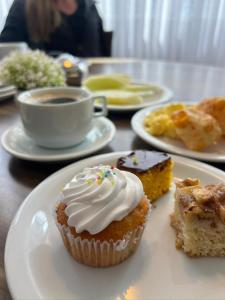 a table with plates of cupcakes and a cup of coffee at Hotel Rieger in Balneário Camboriú +154 photos