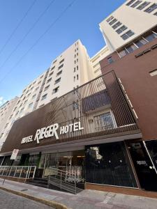 a building with a reiger hotel on a street at Hotel Rieger in Balneário Camboriú