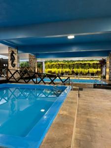 a large swimming pool with a blue ceiling at Hotel Rieger in Balneário Camboriú
