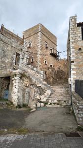 an old brick building with stairs on the side of it at Pyrgos Mitsakou in Vathia