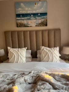 a bedroom with a bed with a picture of the ocean at Beachside Bliss Gordons Bay in Gordonʼs Bay