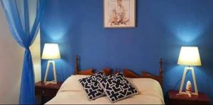 a bedroom with blue walls and a bed with two lamps at San bernardo edificio frente al mar in San Bernardo