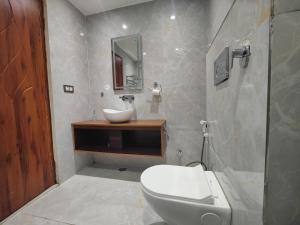 a bathroom with a white toilet and a sink at Nirvana Bliss By Cosy Homes, Malsi in Dehradun +41 photos