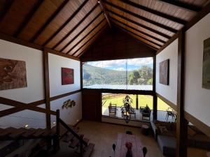 a room with a large window in a house at Casa 04 Monte Boa Vista - Conforto com Piscina Privativa, Sauna e Lareira in Teresópolis