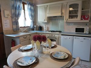 a kitchen with a table with plates and flowers on it at Gite et Studio "L'éclosion des Papillons" à 10 kms de Lens in Courrières