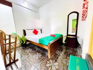 a small bedroom with a bed and a mirror at Kandy Green HillTop Hotel in Kandy