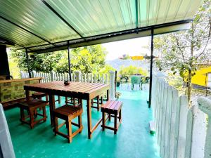 a wooden table and chairs on a patio at Kandy Green HillTop Hotel in Kandy +3 photos