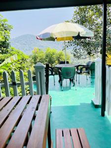 a patio with a table and an umbrella and chairs at Kandy Green HillTop Hotel in Kandy