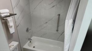a white bathroom with a shower and a white tub at Days Inn by Wyndham Paducah I-24 Exit 4 in Paducah