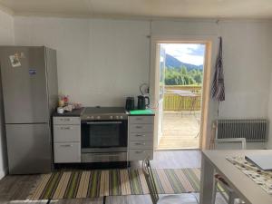 a kitchen with a stove and a refrigerator and a patio at Maple Cottage in Docksta