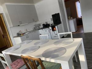a white table and chairs in a kitchen at Maple Cottage in Docksta