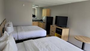 a hotel room with two beds and a flat screen tv at Days Inn by Wyndham Paducah I-24 Exit 4 in Paducah