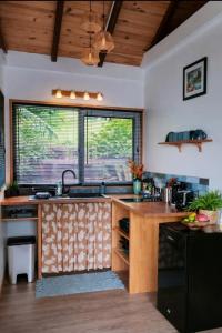 a kitchen with a wooden counter top and two windows at Aimeho Bungalow in Paopao