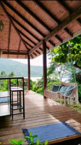 a porch with a swing and a table and a chair at Aimeho Bungalow in Paopao