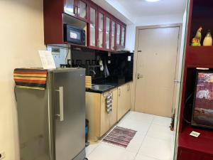 a kitchen with a stainless steel refrigerator and a microwave at MDM Staycation by SMDC in Manila