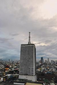 a tall building with a antenna on top of it at MDM Staycation by SMDC in Manila